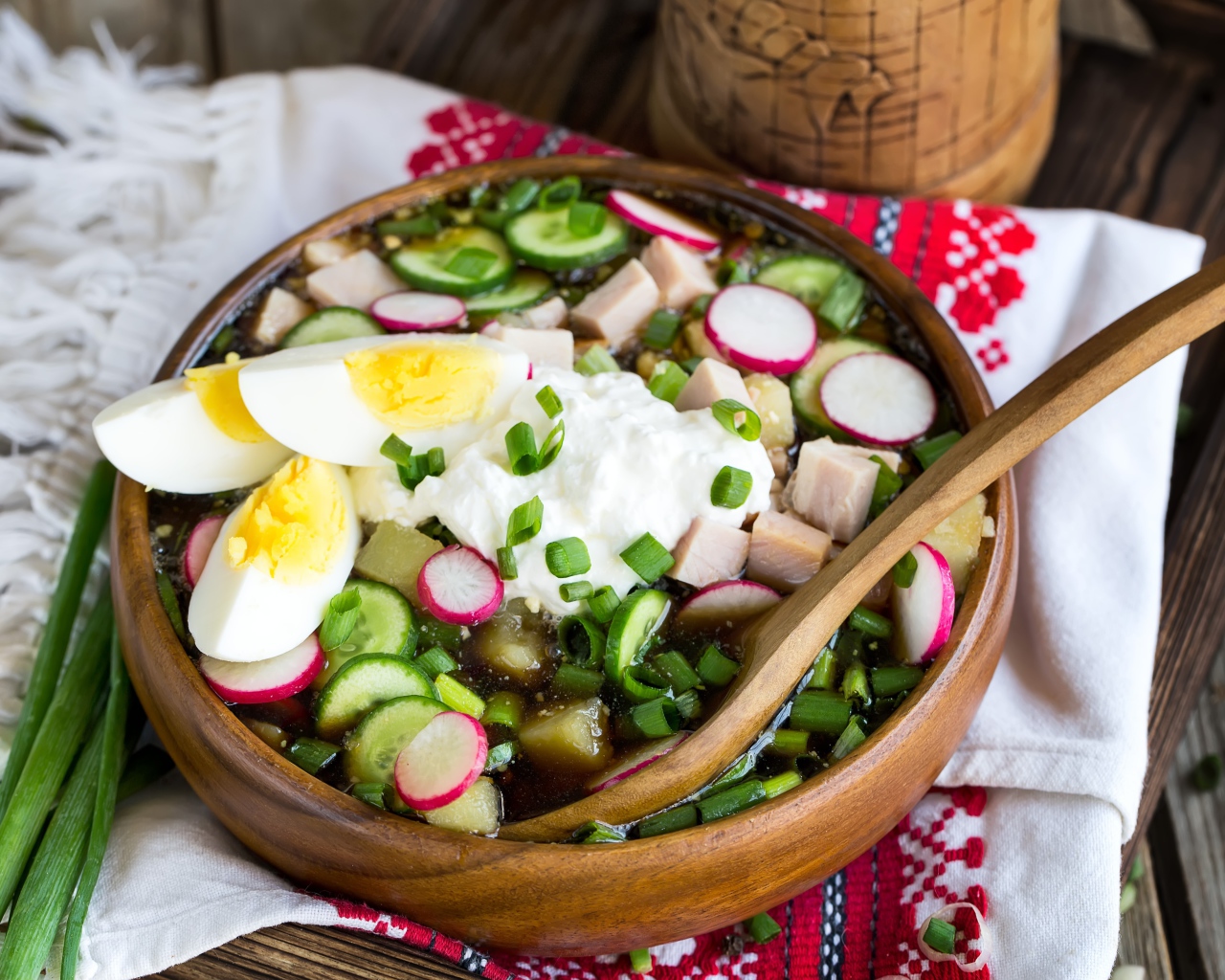 Холодная окрошка в деревянной миске на столе 