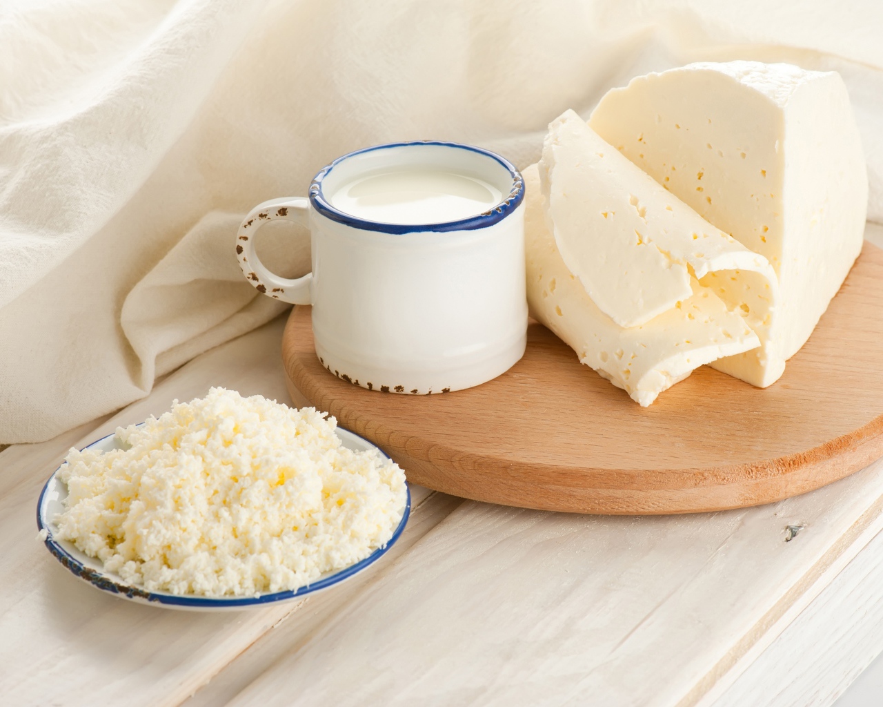 Творог, сыр и кружка молока на столе 