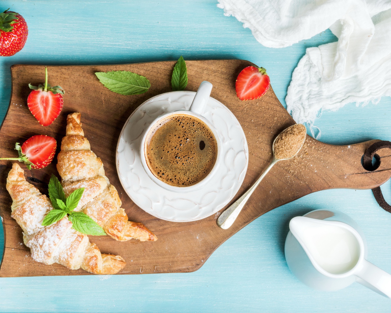 Чашка кофе на доске с клубникой и круассанами