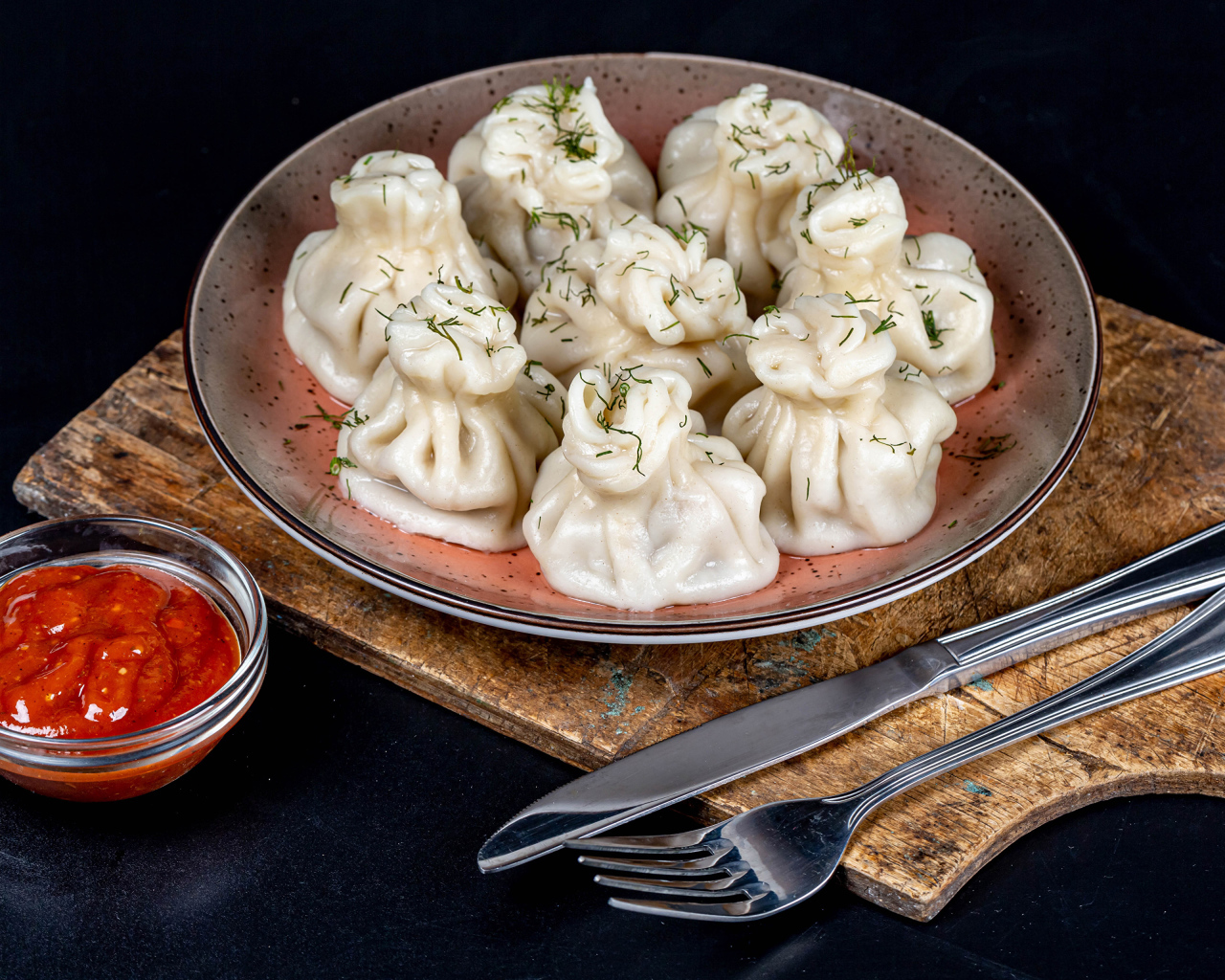 Вкусные горячие хинкали на столе с соусом