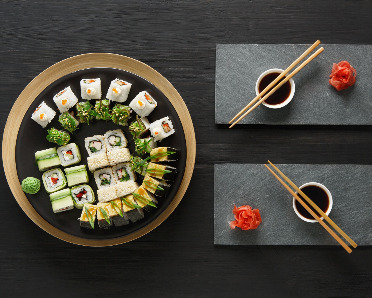 Вкусные  роллы на столе с соевым соусом и палочками 