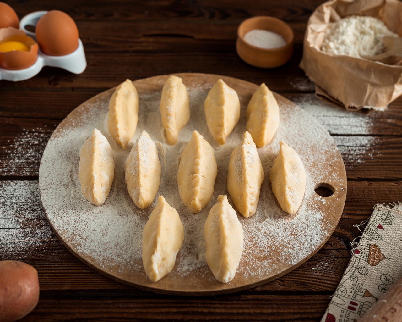 Вареники с картошкой на доске с мукой