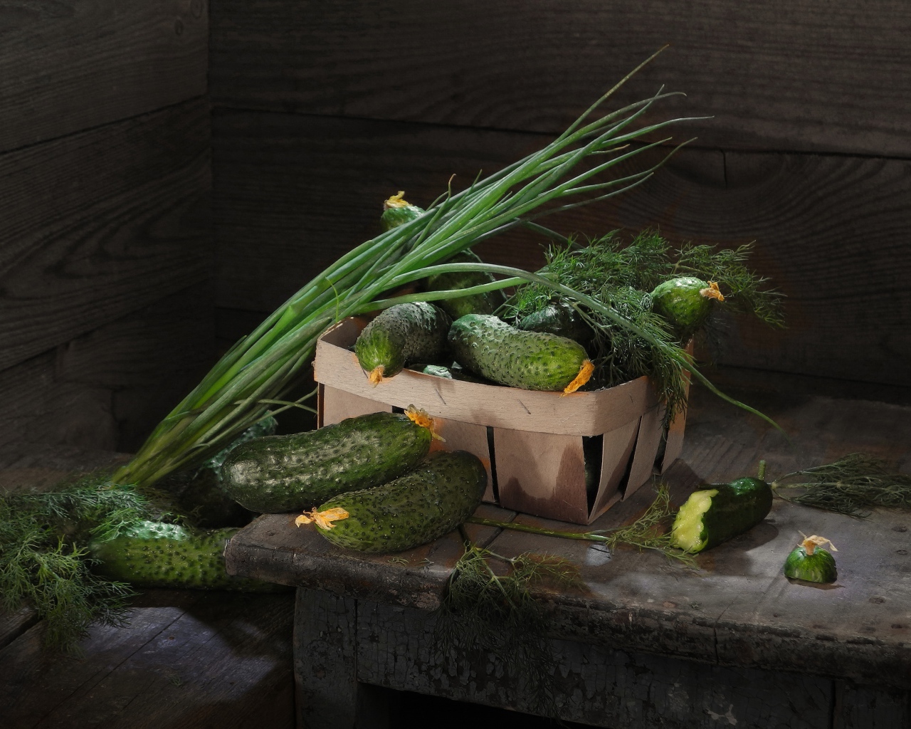 Свежие огурцы на столе  с зеленым луком и укропом