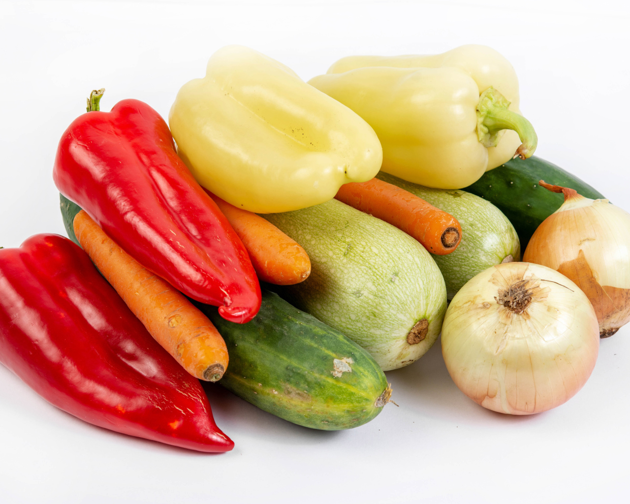 Свежие кабачки, огурцы, морковь, перец и лук на белом фоне