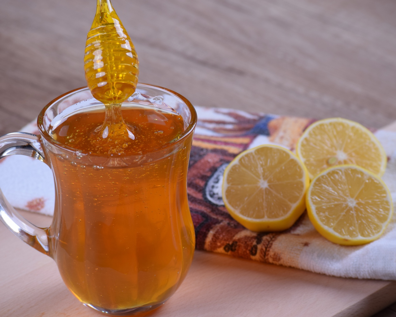 Стеклянная кружка с медом на столе с лимоном