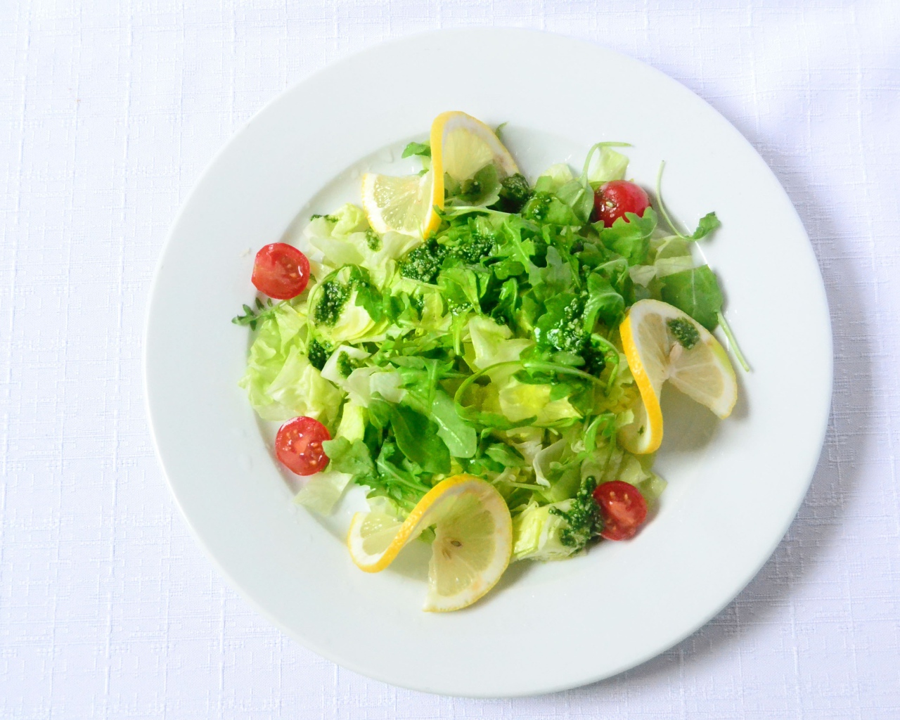 Салат из зелени с лимоном на белом фоне 