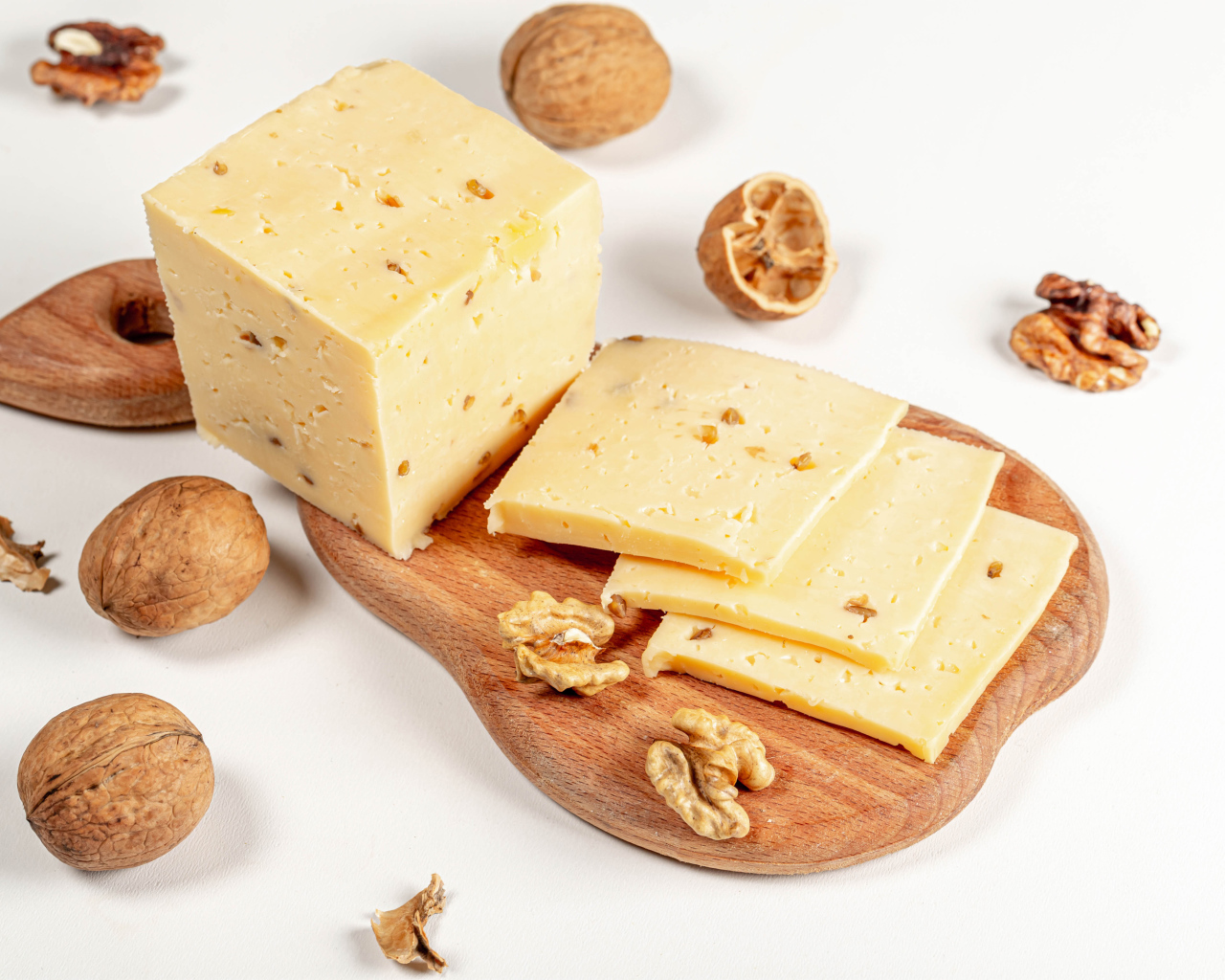 Твердый сыр на доске с грецкими орехами 