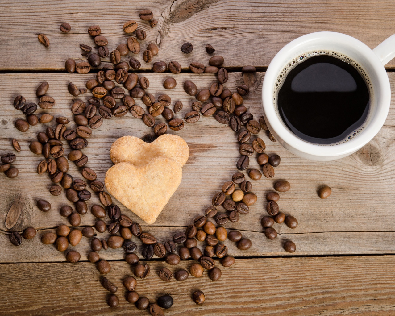 Печенье в форме сердца на столе с зернами и чашкой кофе 