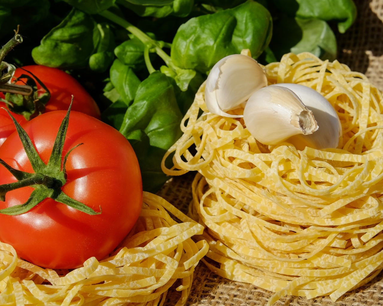 Домашняя лапша на столе с помидорами и базиликом