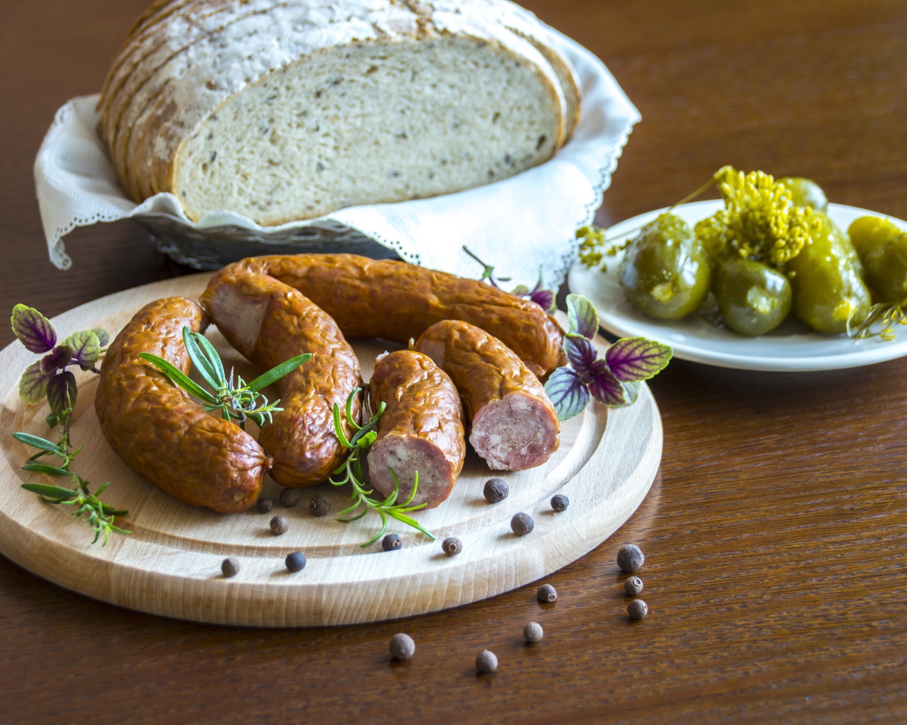 Домашняя колбаса на столе с хлебом и маринованными огурцами