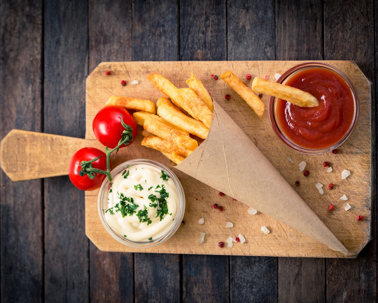 Кетчуп, соус и картофель фри на доске с помидорами