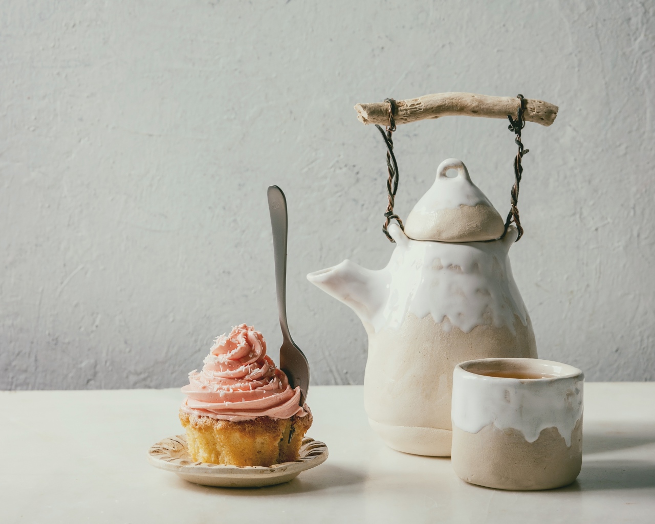 Чайник с чашкой на столе с кексом