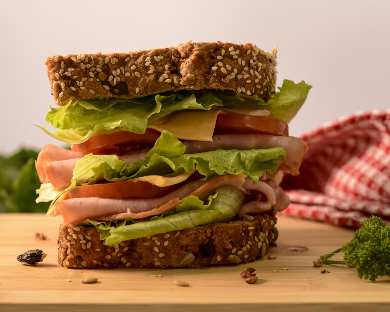 Большой бутерброд с ветчиной, сыром, помидорами и листьями салата 