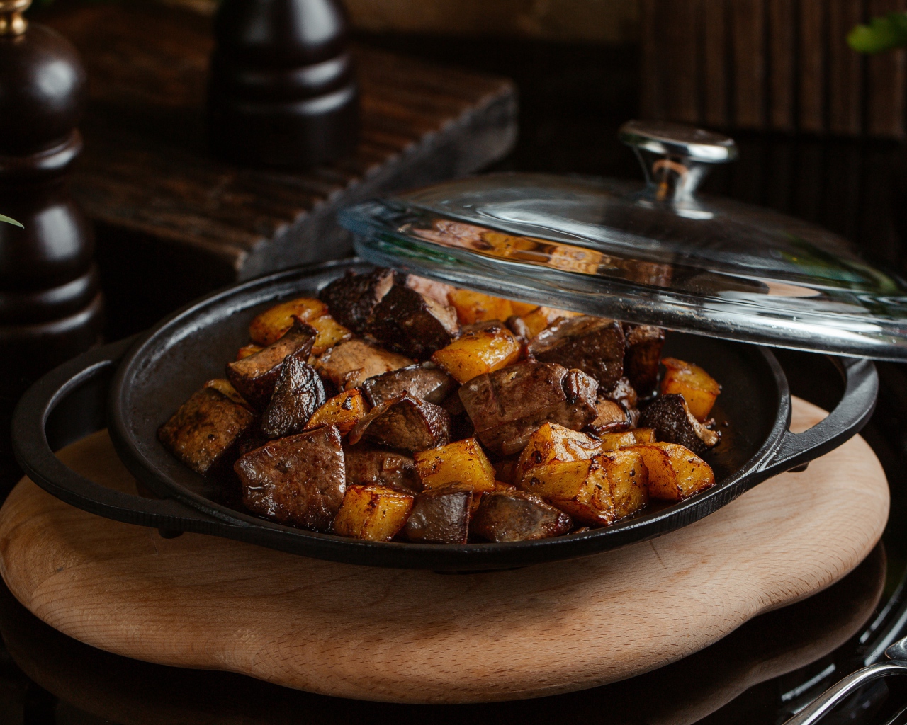 Печень с картофелем в сковороде на столе