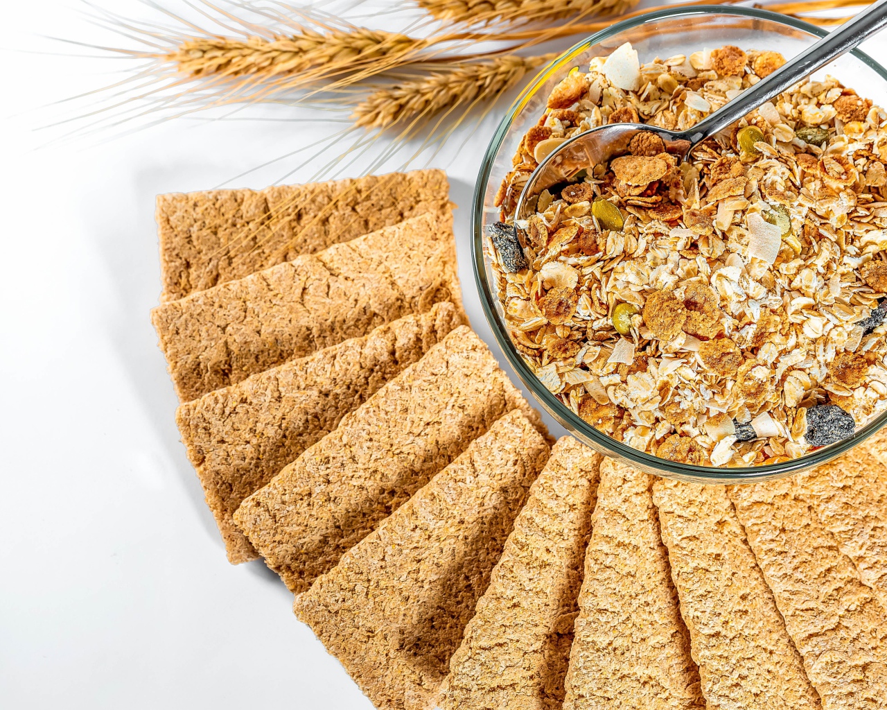 Мюсли в тарелке на столе с хлебцами 