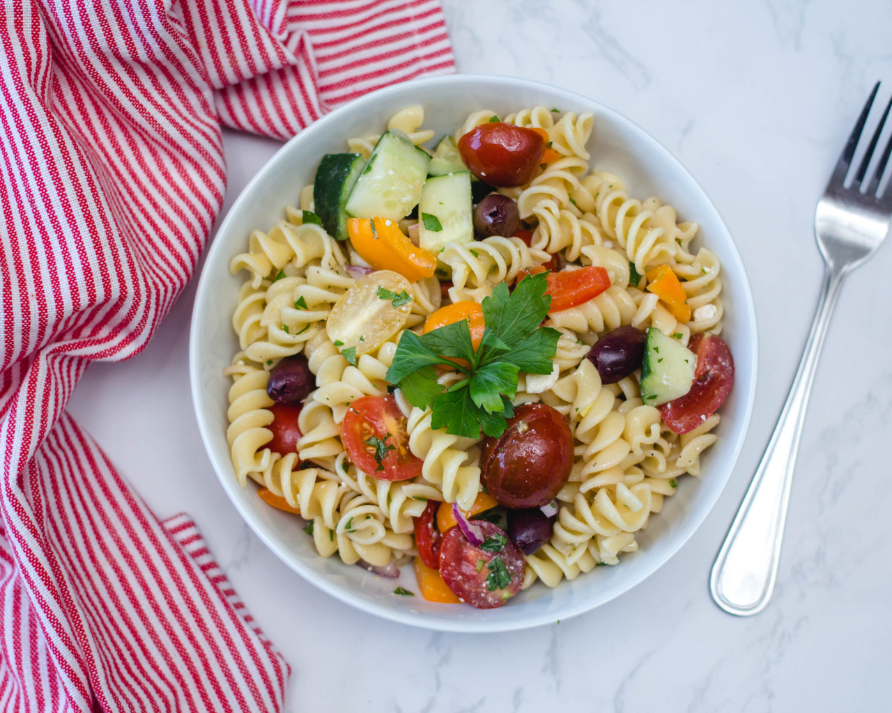 Макароны в тарелке с овощами на столе 