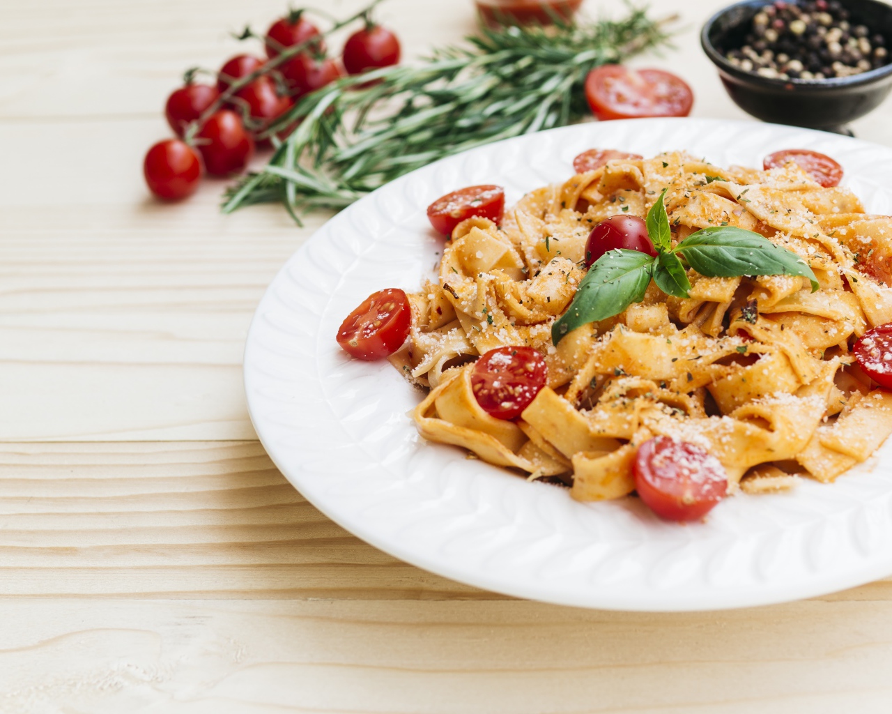 Паста с помидорами черри на белой тарелке