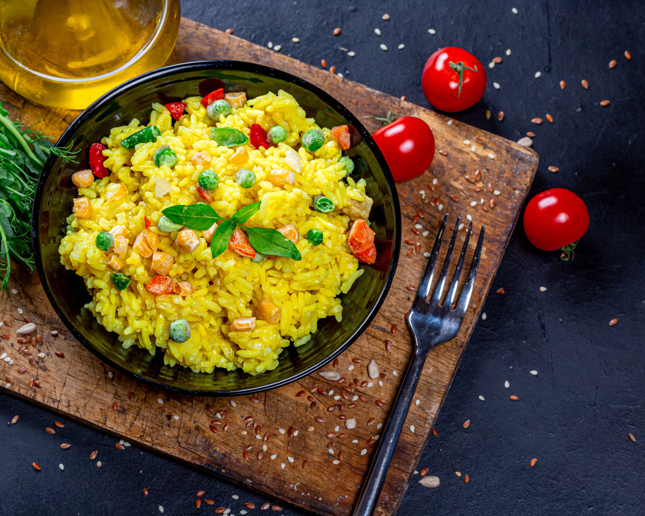 Рис с овощами на столе с маслом, зеленью и помидорами 