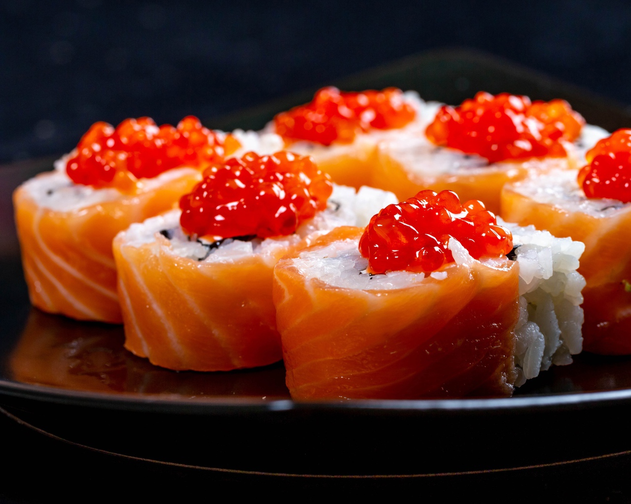 Роллы с красной рыбой и икрой на тарелке