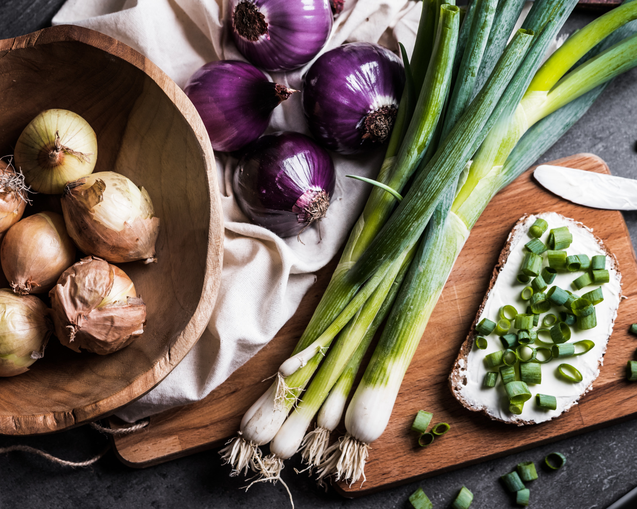 Бутерброд на столе с зеленым и репчатым луком