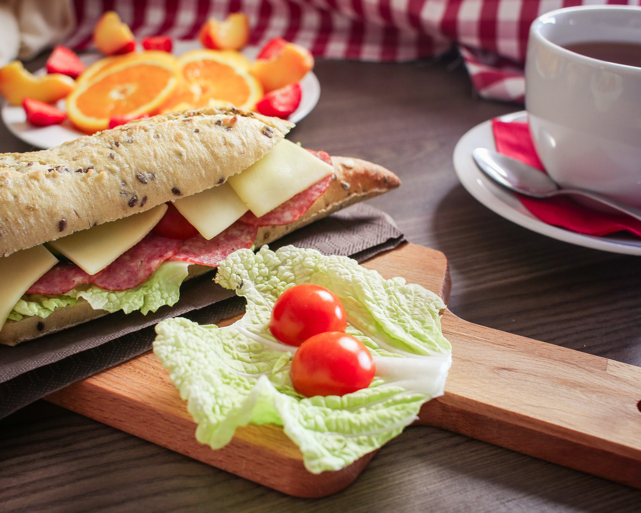 Бутерброды на столе с фруктами и чашкой чая