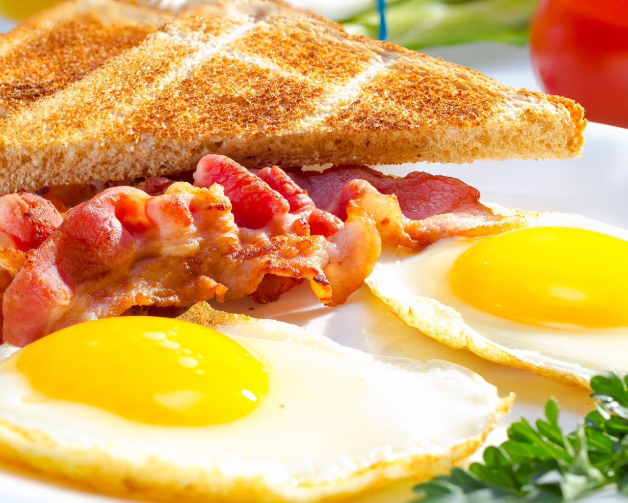 Яичница, бекон и гренки на завтрак на столе 