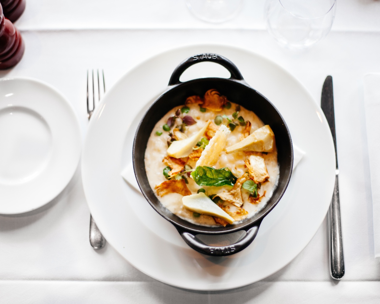 Суп в миске стоит на белой тарелке 