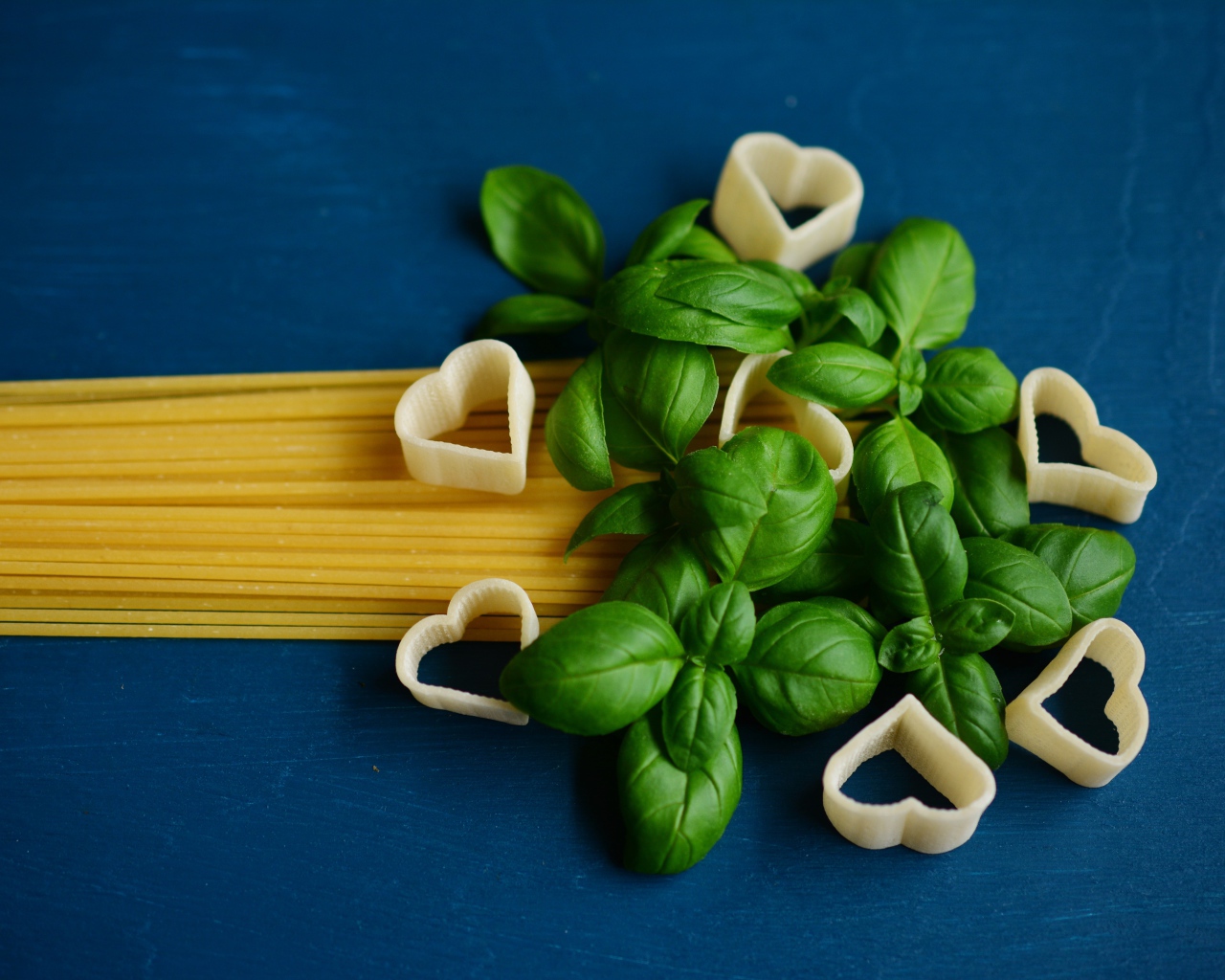 Spaghetti with basil on a blue background