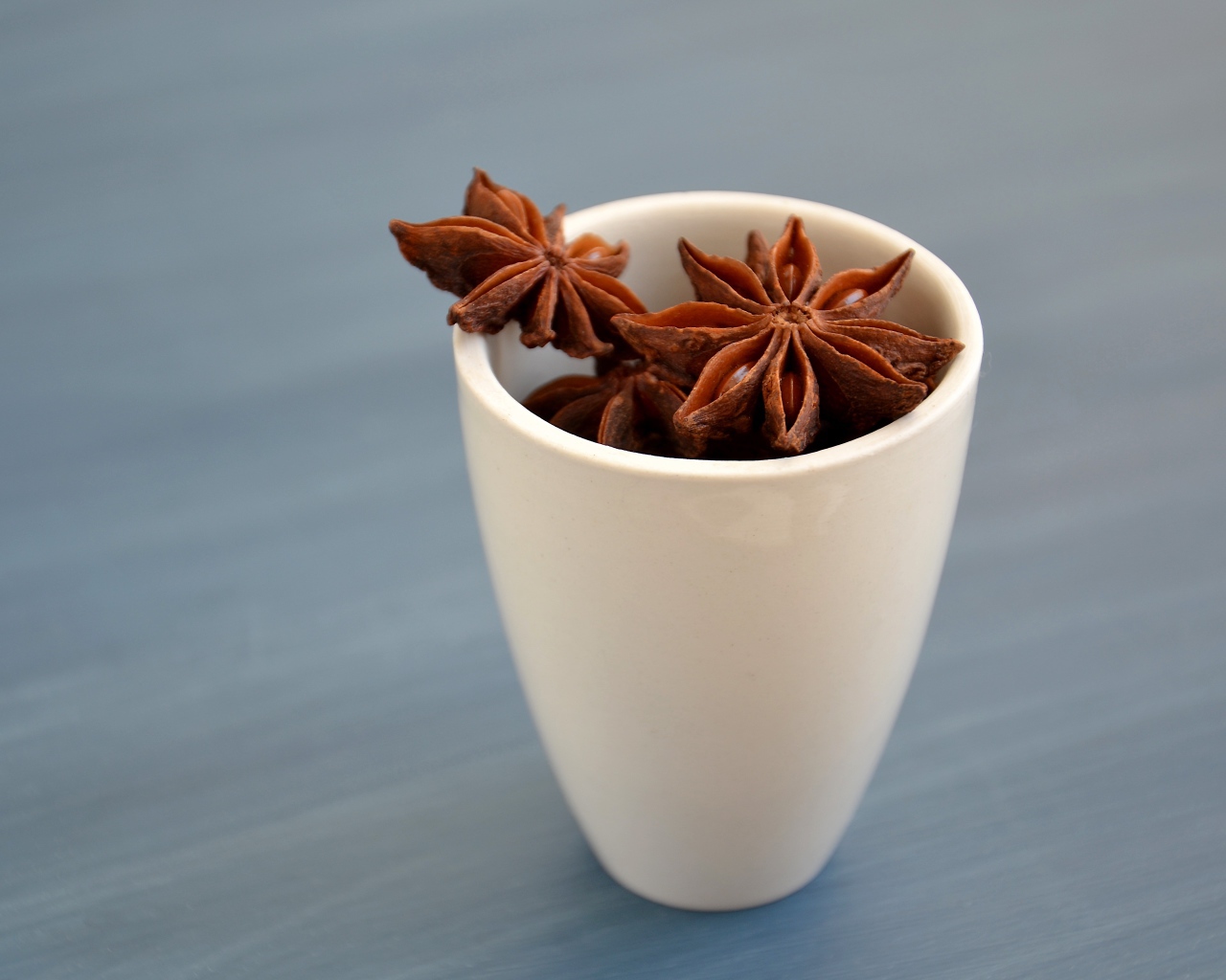 Star anise stars in a white cup on the table