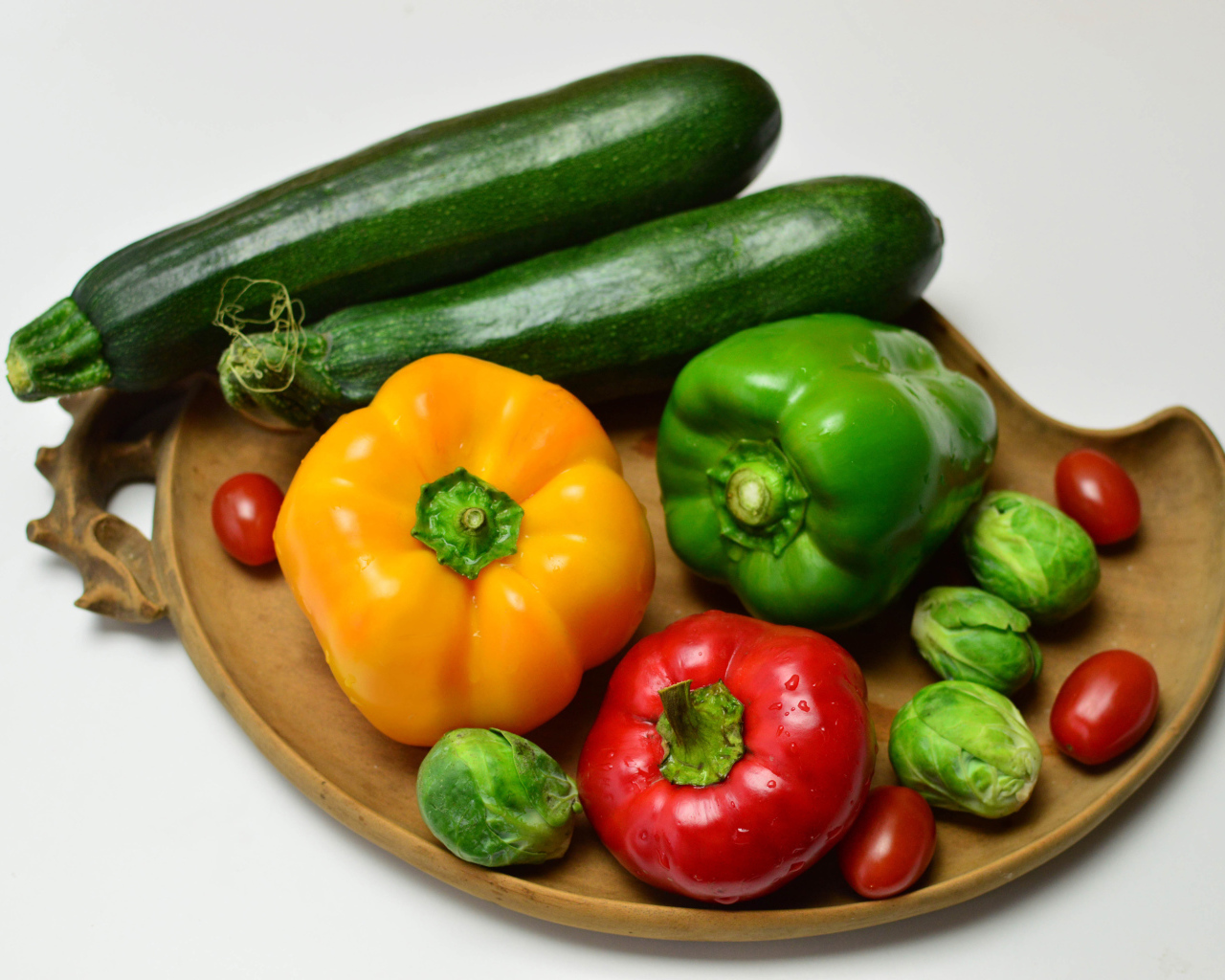 Sweet pepper, zucchini, tomatoes and brussels sprouts on a gray background
