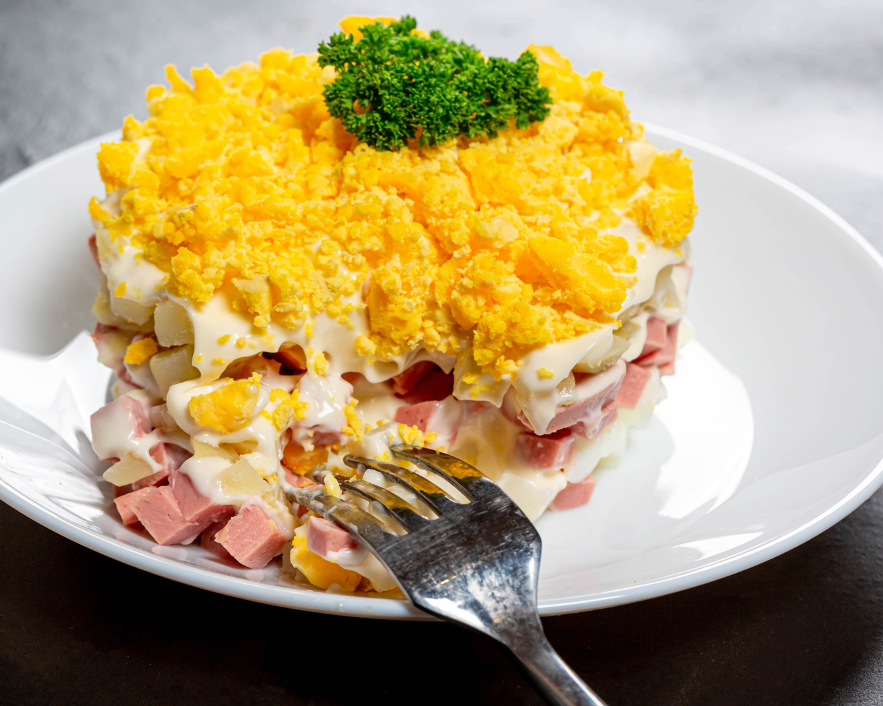 Вкусный салат на белой тарелке с вилкой