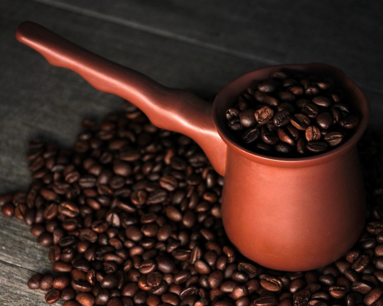 Турка с кофейными зернами на столе 