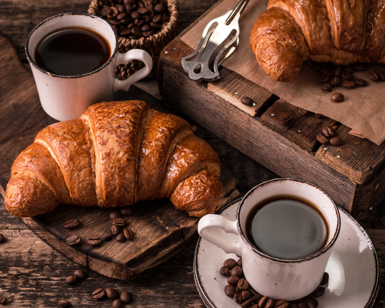 Две чашки кофе на столе с рогаликами и зернами 