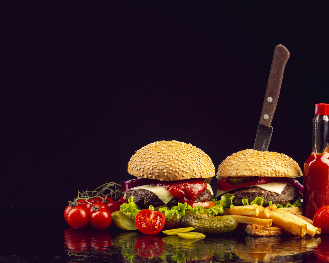 Два гамбургера на столе с ножом, овощами и кетчупом 