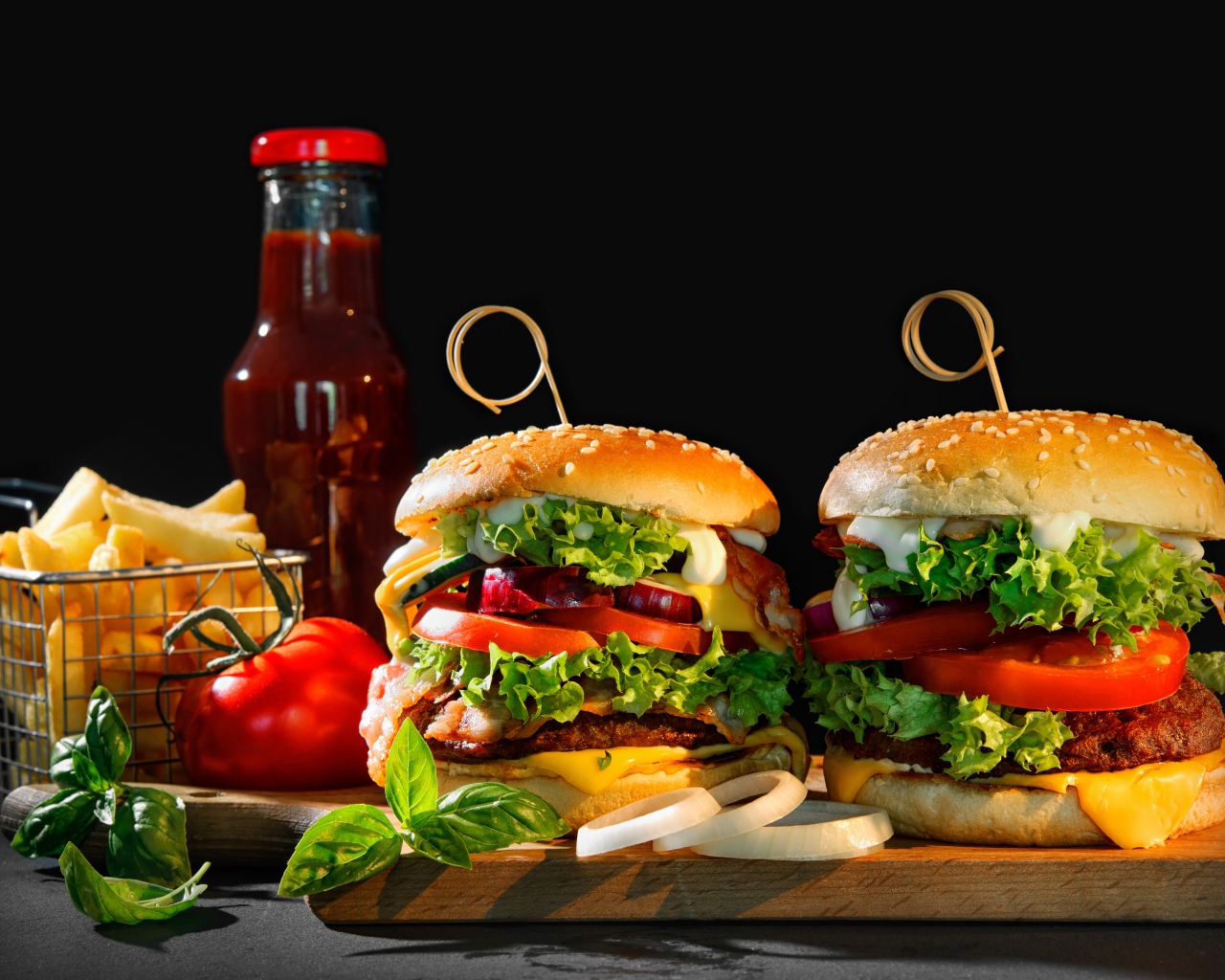 Два гамбургера на столе с картофелем фри, кетчупом и помидорами