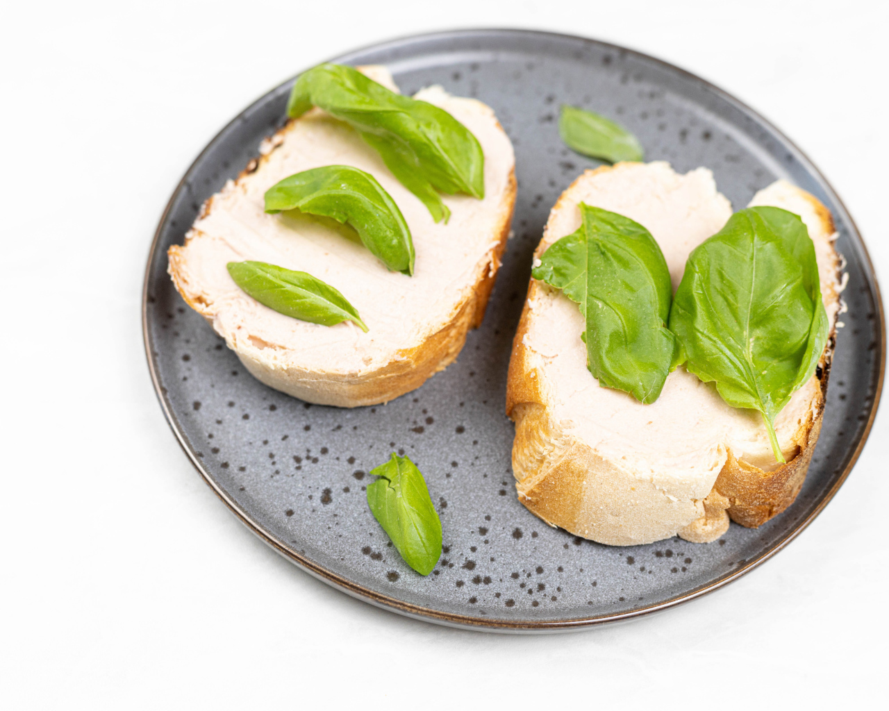 Два бутерброда с листьями базилика 