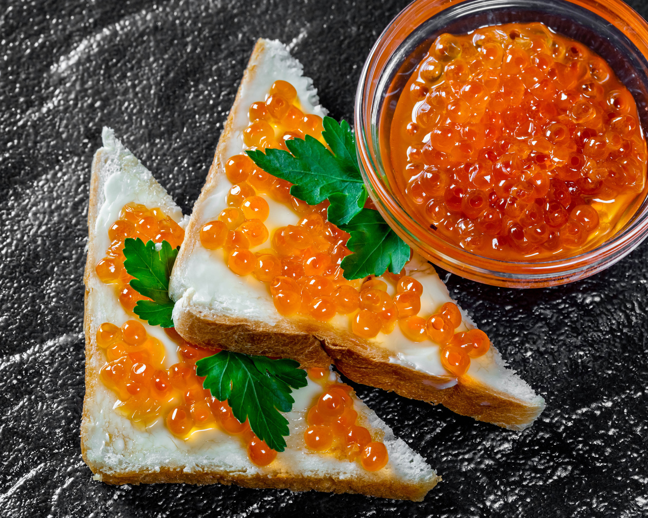 Два бутерброда с красной икрой на столе