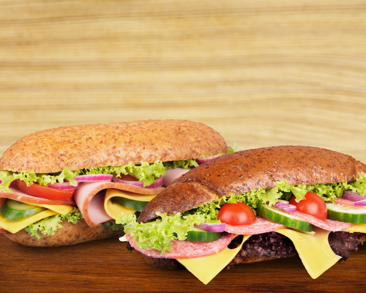 Два вкусных бутерброда с овощами и колбасой на столе 