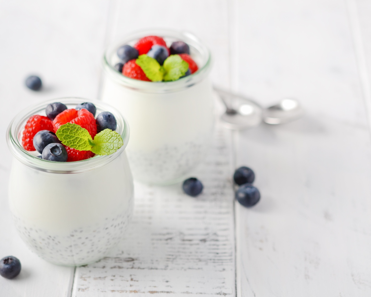 Йогурт в баночке с семенами годжи и ягодами черники и малины