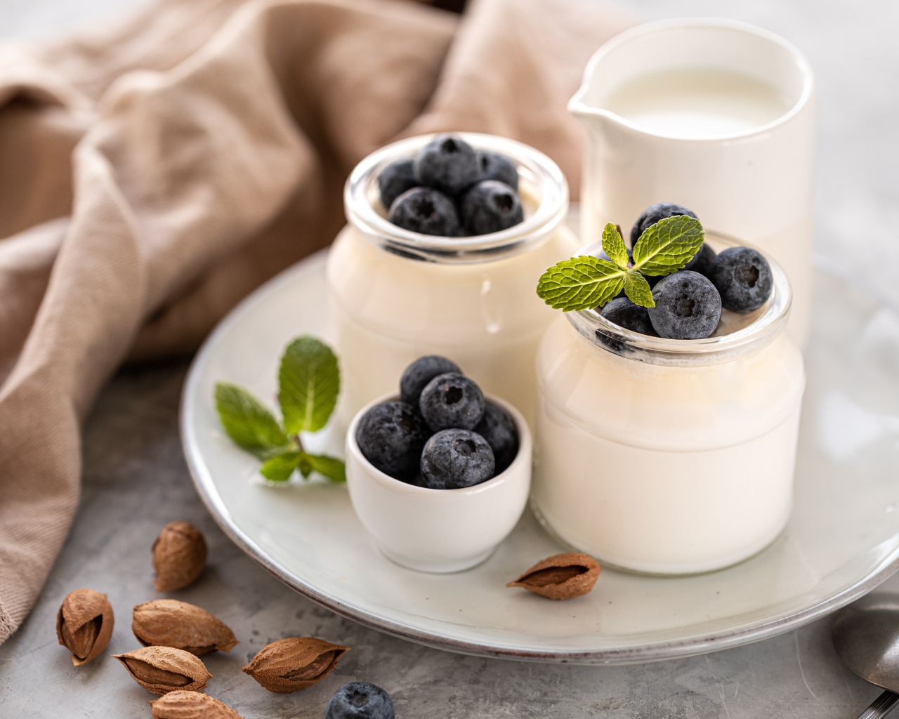 Йогурт на тарелке с ягодами черники 