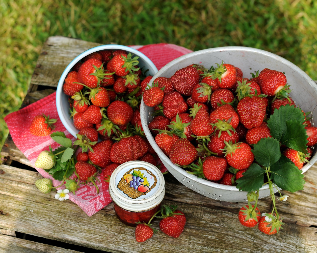 Много спелой ароматной клубники на столе с джемом 
