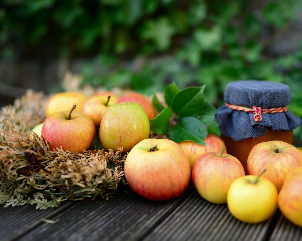 Яблоки и банка варенья на столе 