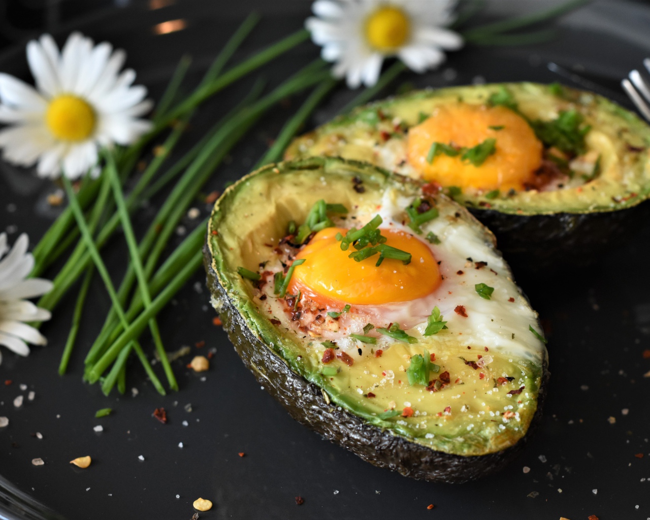 Baked avocado with scrambled eggs in a pan