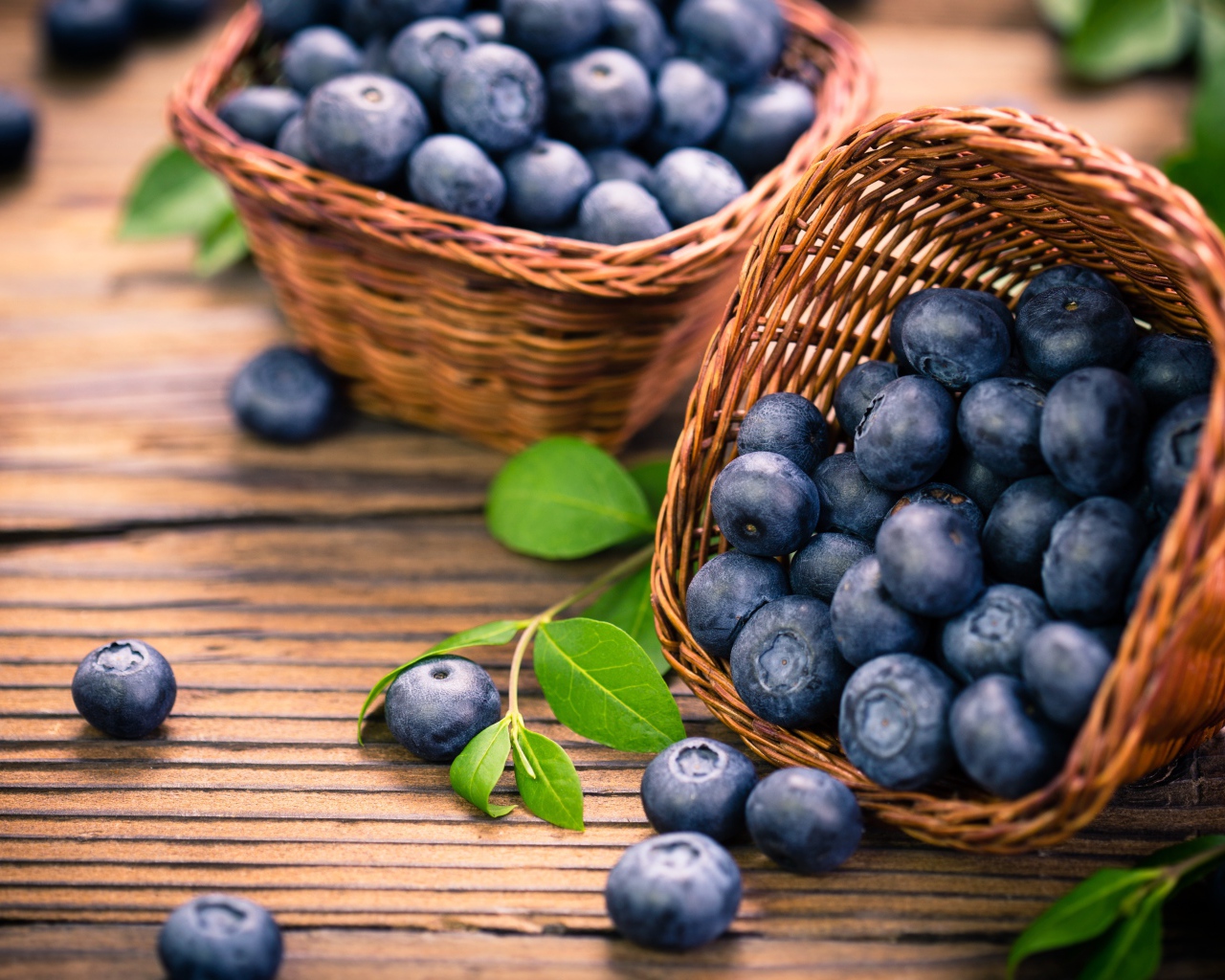 Синие ягоды черники в корзинках на столе 