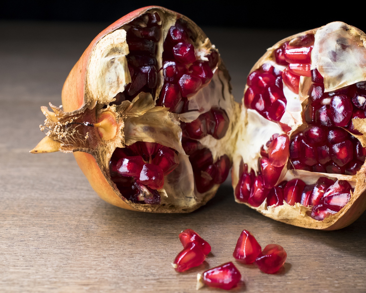 Разломанный красный гранат на столе 