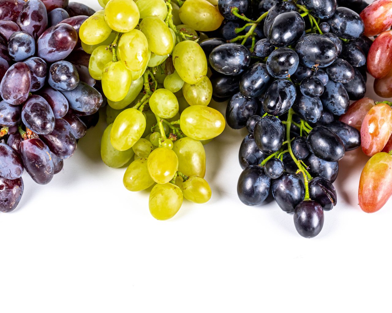 Грозди разноцветного винограда на белом фоне