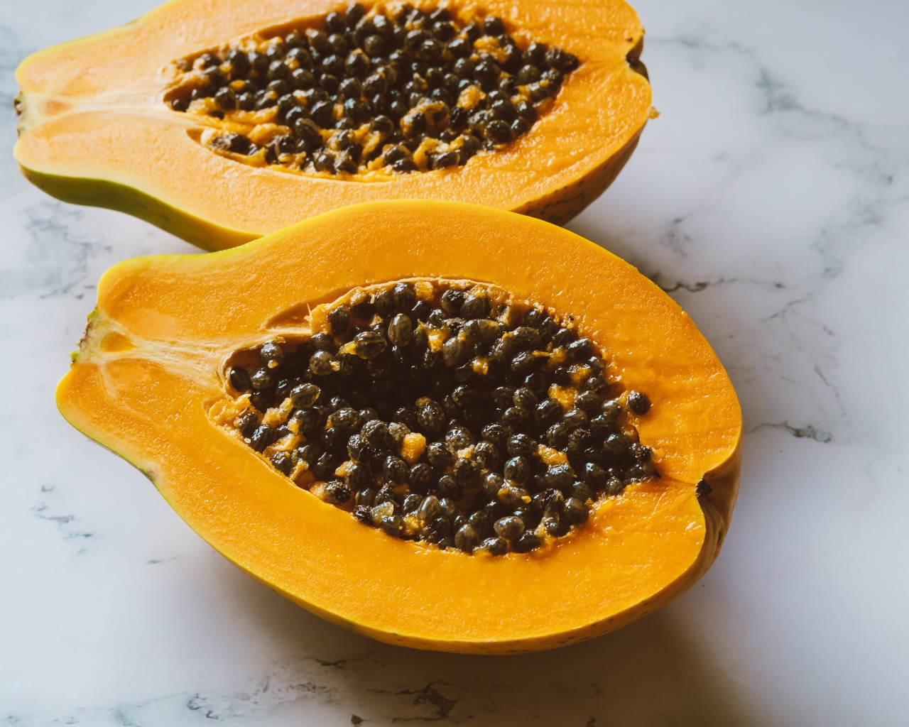 Разрезанный плод папайи на столе 