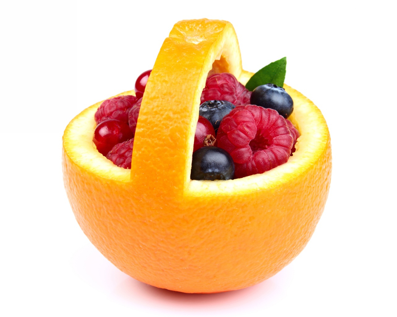 Свежие ягоды в кожуре апельсина на белом фоне