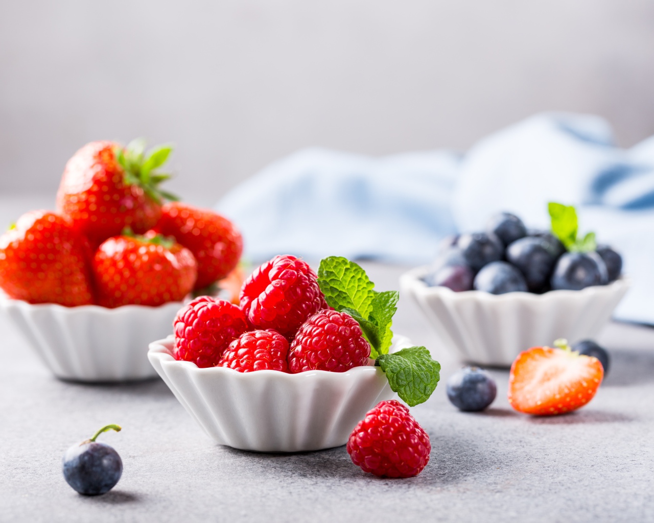 Свежие ягоды малины, клубники и черники на столе