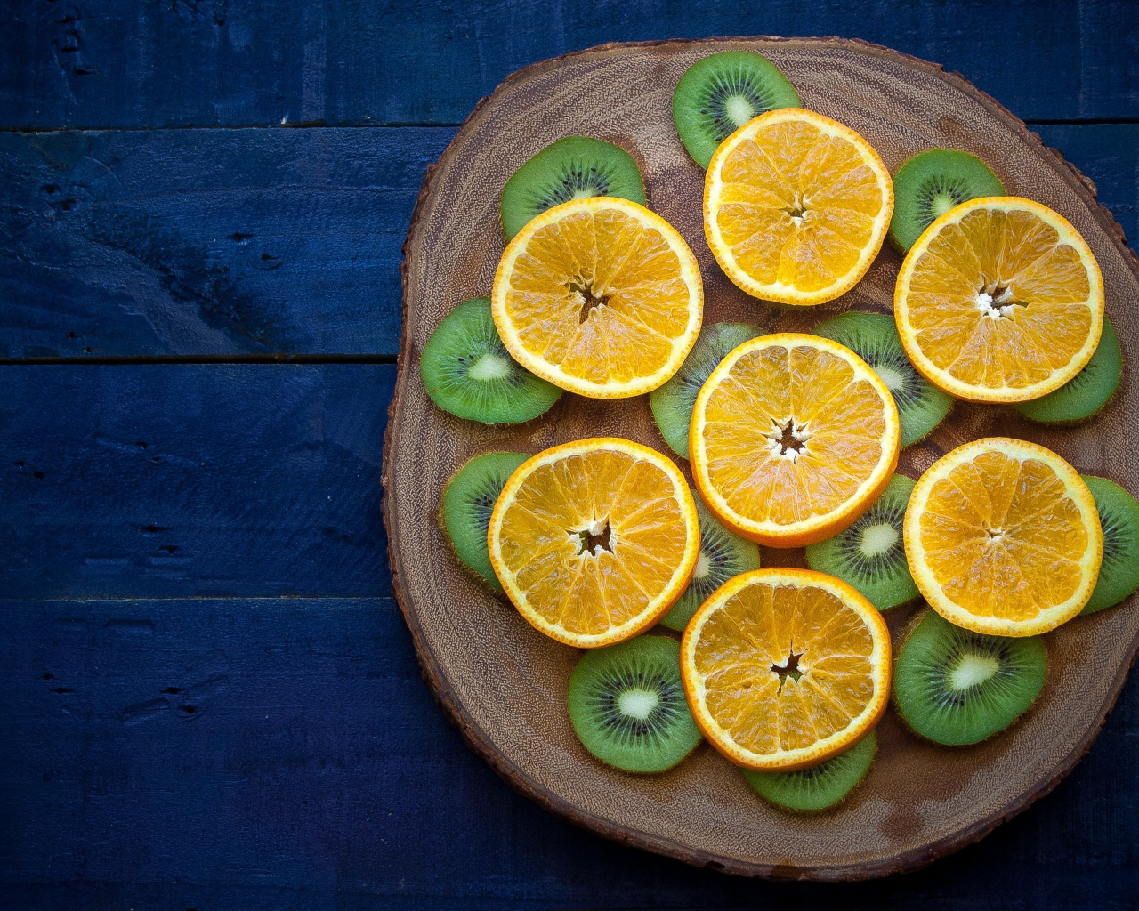 Кружочки киви с апельсинами на доске 